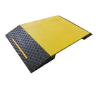 Three-quarter view of the ramp, yellow deck panel meeting the ribbed black chequer-tread approach slope