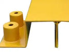 Close-up of two yellow cylindrical locating spigots on the bridge ramp's base plate, folded deck edge alongside