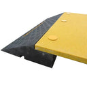 Side close-up showing the low black rubber slope and its cable channel opening beneath the yellow deck