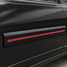 Black door moulding with red insert stripe fitted to a black car door, close-up