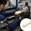 Machinist loading a short cream nylon bar into a large lathe chuck, inset of a longer cream rod