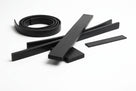 Black rectangular rubber strip cut into lengths, one coiled, on white background
