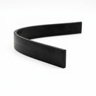 Length of flat black rectangular rubber strip curved on white background