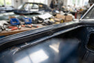 Black rectangular rubber strip fitted along a dark blue classic car's door frame