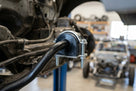 Anti-roll bar bush clamped in a metal bracket around the bar, in-situ