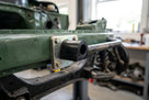 Anti-roll bar bush mounted to a green chassis rail with a metal bracket