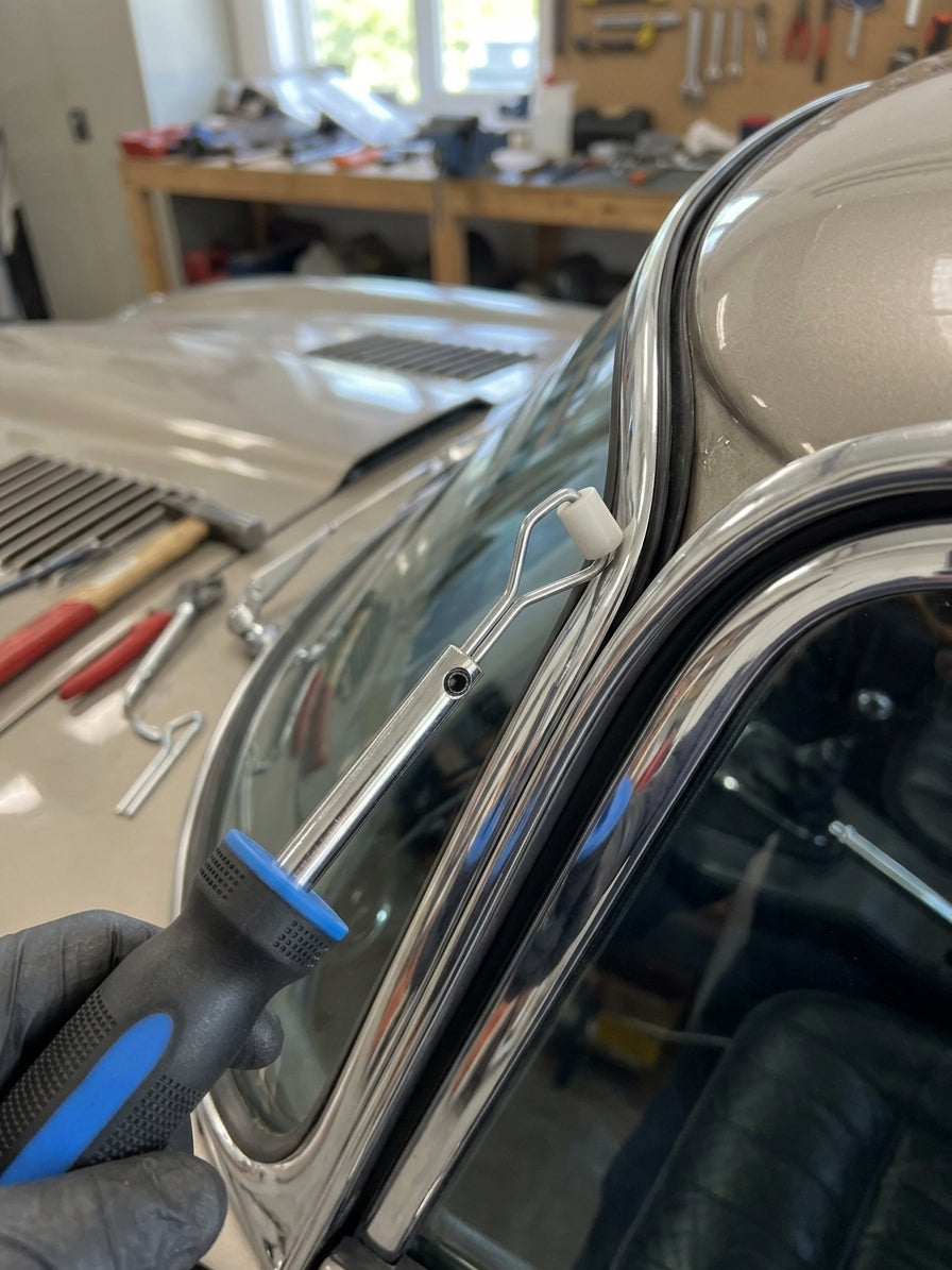 Glazing strip fitting tool in use, seating chrome trim into a car's window channel