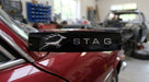 Black STAG side badge fitted to the rear wing of a red Triumph Stag Mk2