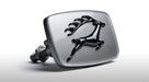 Silver front grille badge with black leaping stag emblem, angled studio shot