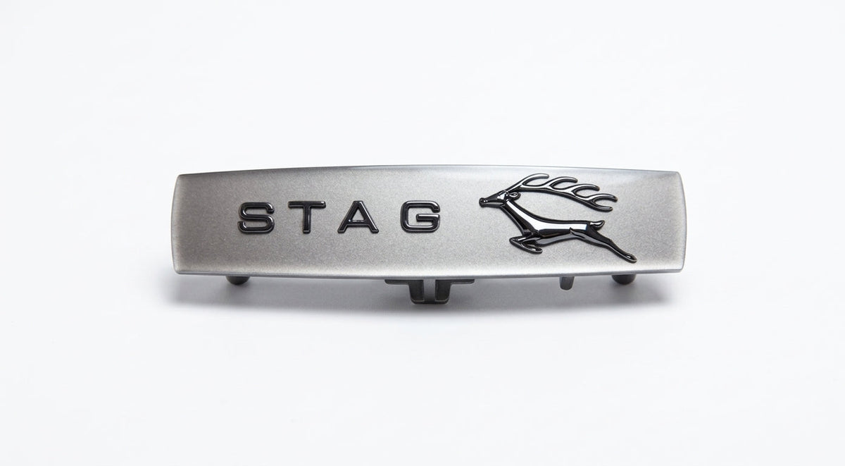 Brushed silver STAG side badge with black leaping stag emblem, studio shot