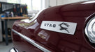 Silver STAG side badge fitted to the rear wing of a maroon Triumph Stag Mk1