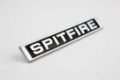 Chrome SPITFIRE script badge angled on white background, studio shot