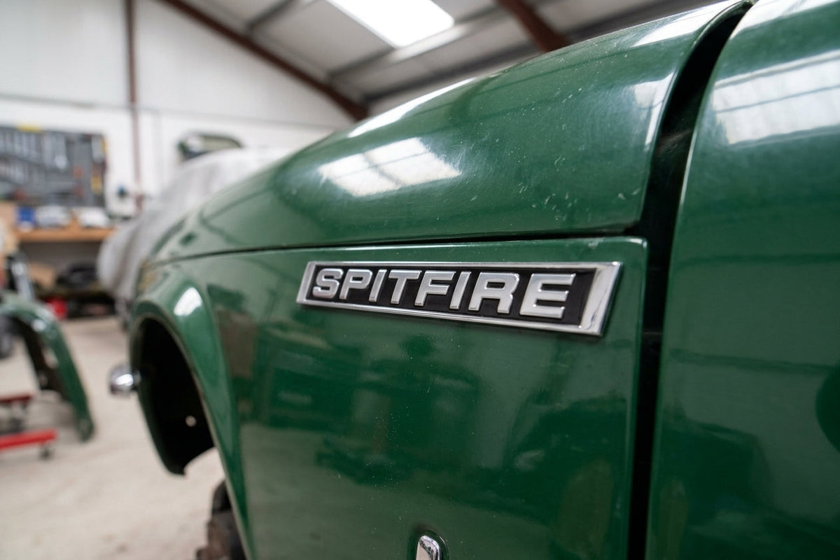 SPITFIRE badge fitted to a green Spitfire's wing in a workshop