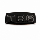 Black enamelled TR6 badge with chrome surround, studio shot on white