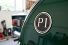 PI badge fitted to the rear of a dark green classic car