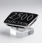 2500 Injection badge fitted to the chrome grille surround of a maroon classic car