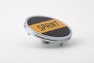 Round chrome-rimmed SPRINT badge angled on white background, studio shot