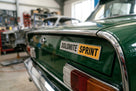 DOLOMITE SPRINT boot badge fitted to a green car's boot lid in a workshop