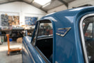 Blue and chrome Triumph pillar badge fitted to a blue car's roof pillar