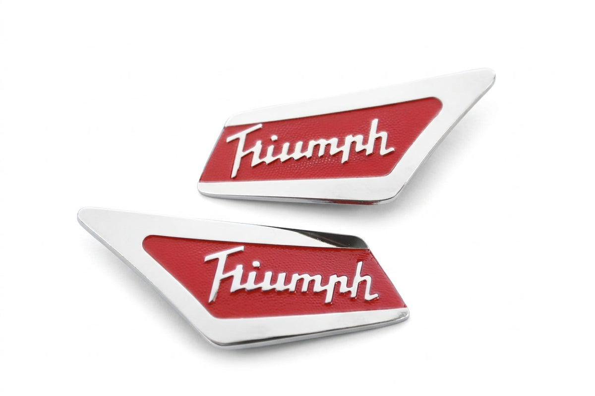 Pair of red and chrome Triumph script pillar badges, studio white background