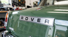 Silver ROVER badge fitted to the boot lid of a green classic car