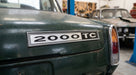 2000TC badge fitted to the boot lid of a green classic car in a workshop