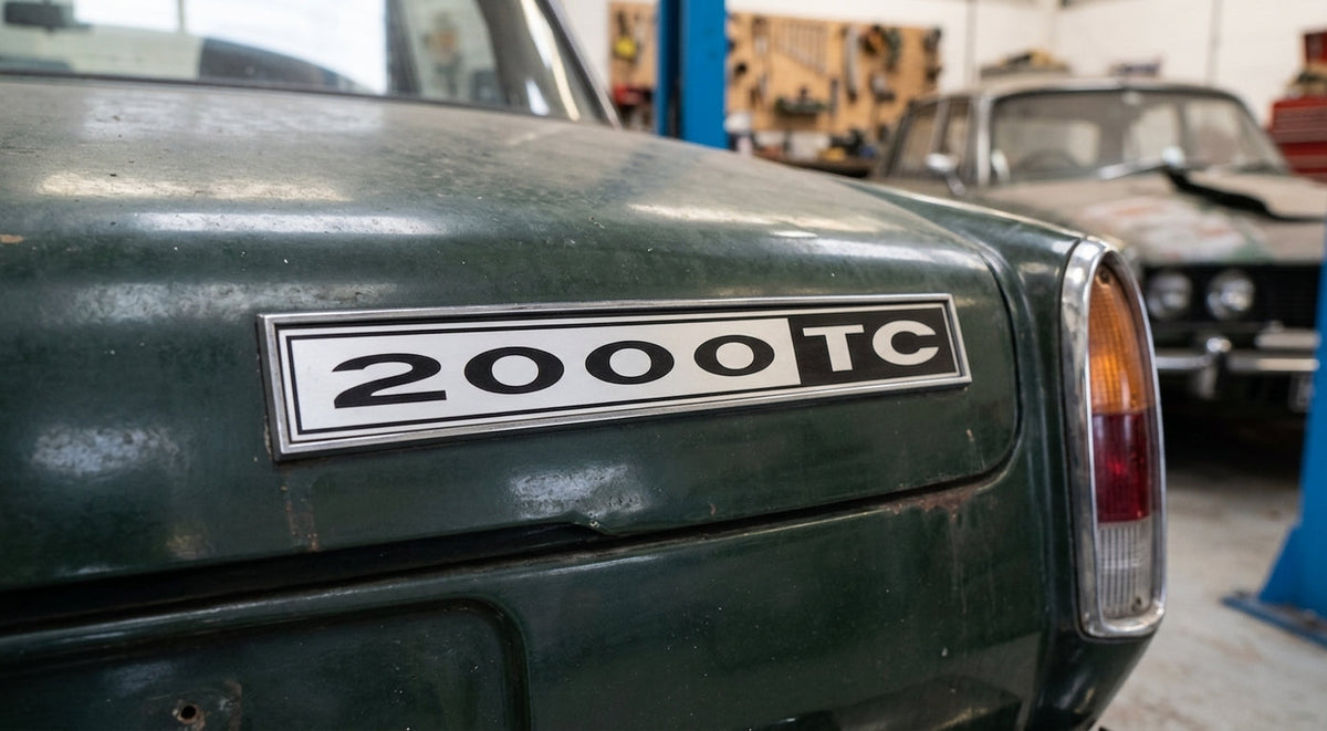 2000TC badge fitted to the boot lid of a green classic car in a workshop