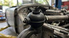Black rubber rod end gaiter fitted to a track rod end on a car undergoing restoration