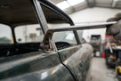 Metal fitting tool being used to press trim onto a car window frame