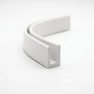 White PVC wallboard edge trim curled into a loop, showing U-shaped channel