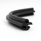 Coiled length of black battery box seal photographed on a white background