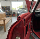 Red PVC edging strip fitted to a door edge on a red classic car with the bonnet open
