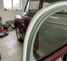 White PVC edging strip fitted around a window aperture on a green and maroon classic car