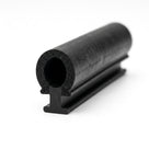 Angled studio shot of black sponge door seal with a round bulb on a T-shaped foot, porous bore visible.