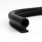 Coiled black rubber keyhole seal showing round bore and footed base