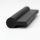 Black rubber P-profile with round bulb and flat tail, showing porous cut end