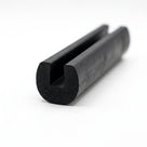 Black EPDM edge trim profile coiled, close-up end-on view of rounded U-shaped groove