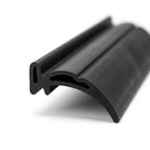 Black rubber T-section extrusion with a curved wing, angled studio shot