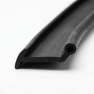 Black solid neoprene piping with a barbed fin and round bead, close-up on the smooth cut end