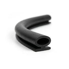 Coiled black rubber bulb door seal with slotted foot, curved end-on view
