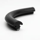Curved length of black solid neoprene T-section, close-up on the notched retaining foot at the cut end
