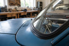 Black windscreen surround fitted around a blue Escort's curved windscreen, workshop