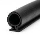 Black rubber tube seal with internal channel, coiled length on white background