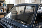 Black windscreen surround fitted to a dark blue Cortina's rear screen, workshop