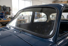 Black rubber seal fitted around the windscreen of a dark blue classic car