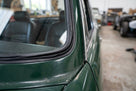 Black rubber seal fitted around a rear side window frame on a green Triumph Stag