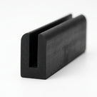 Black EPDM U-channel profile standing upright, plain white background shot of rounded-top block