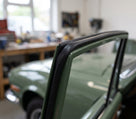 Black rubber seal fitted along the door top frame of a green Triumph Stag