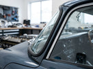 Windscreen seal fitted to the frame of a grey classic Jaguar E-Type, dashboard visible