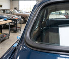 Windscreen seal fitted to the rear side window frame of a dark blue classic Jaguar